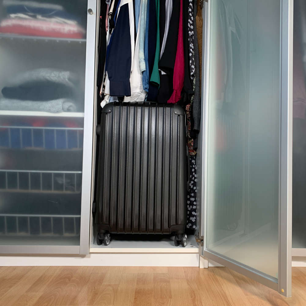 Die Bonsanto Mini Grow Box sieht aus wie ein schwarzer Koffer und steht in einem Kleiderschrank unterhalb der Kleiderstange.